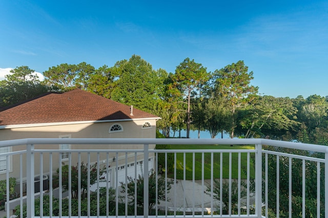 exterior space featuring a garage, a water view, and a balcony