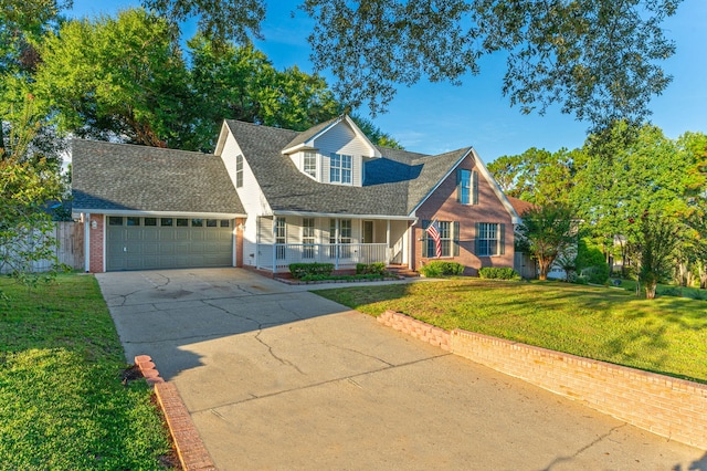 new england style home featuring a front lawn, a garage, and covered porch