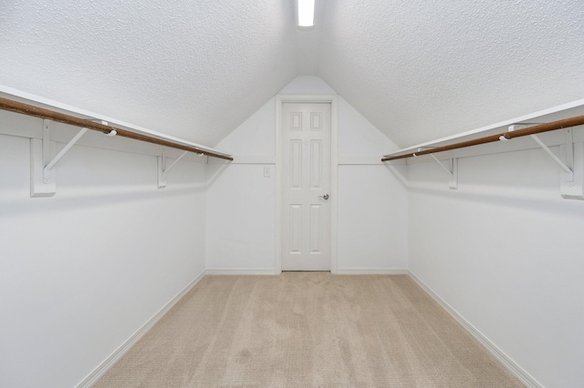 spacious closet featuring carpet and vaulted ceiling