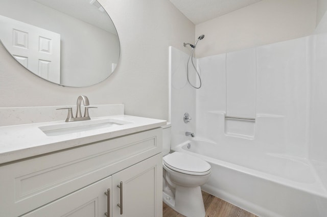 full bathroom featuring toilet, tub / shower combination, a textured ceiling, vanity, and wood finished floors