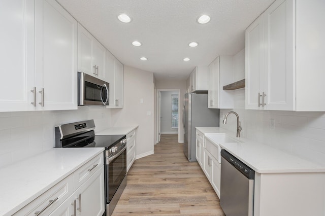 kitchen featuring white cabinetry, appliances with stainless steel finishes, and a sink