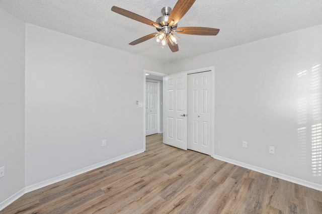 empty room featuring a ceiling fan, a textured ceiling, baseboards, and wood finished floors