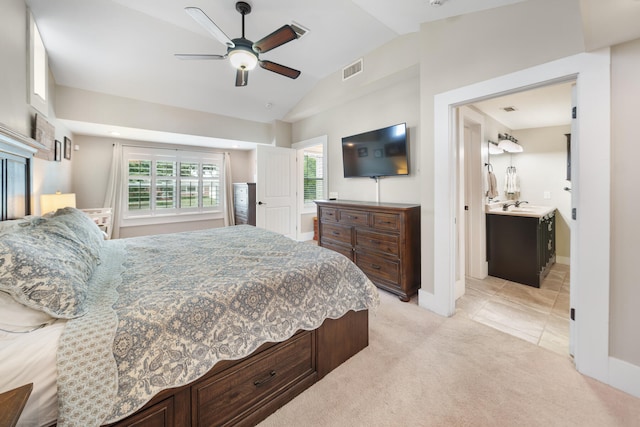 carpeted bedroom with lofted ceiling, ceiling fan, ensuite bathroom, and sink