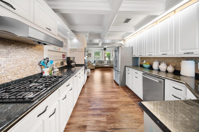 kitchen featuring coffered ceiling, backsplash, wood-type flooring, stainless steel appliances, and white cabinets