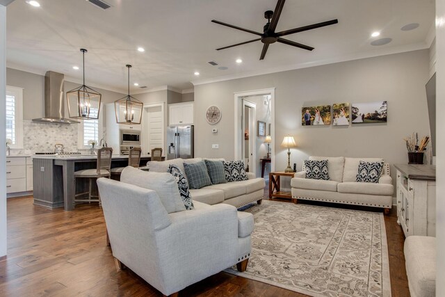 living room featuring ceiling fan, dark hardwood / wood-style floors, and crown molding