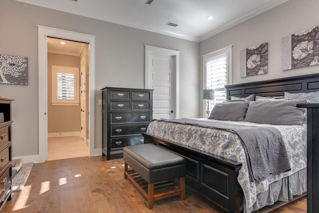 bedroom with multiple windows, crown molding, and dark wood-type flooring