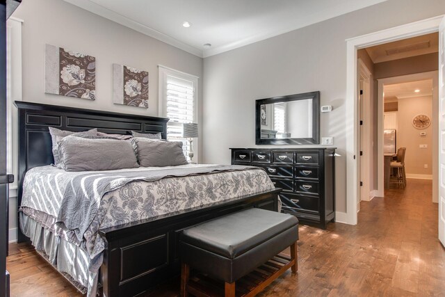 bedroom with dark hardwood / wood-style flooring and crown molding