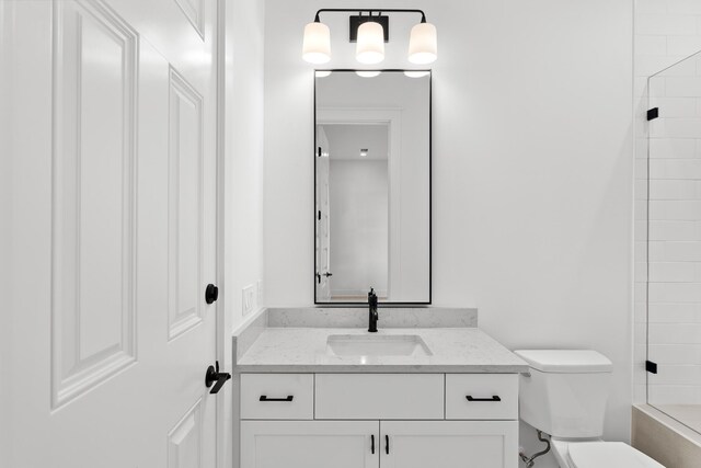 bathroom with a shower, vanity, and toilet