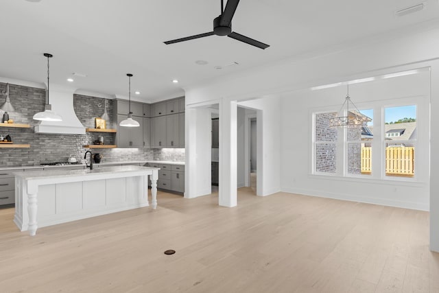 kitchen featuring gray cabinets, custom range hood, backsplash, and light hardwood / wood-style flooring