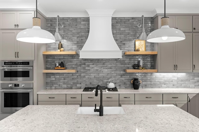 kitchen with tasteful backsplash, light stone countertops, stainless steel appliances, and custom range hood