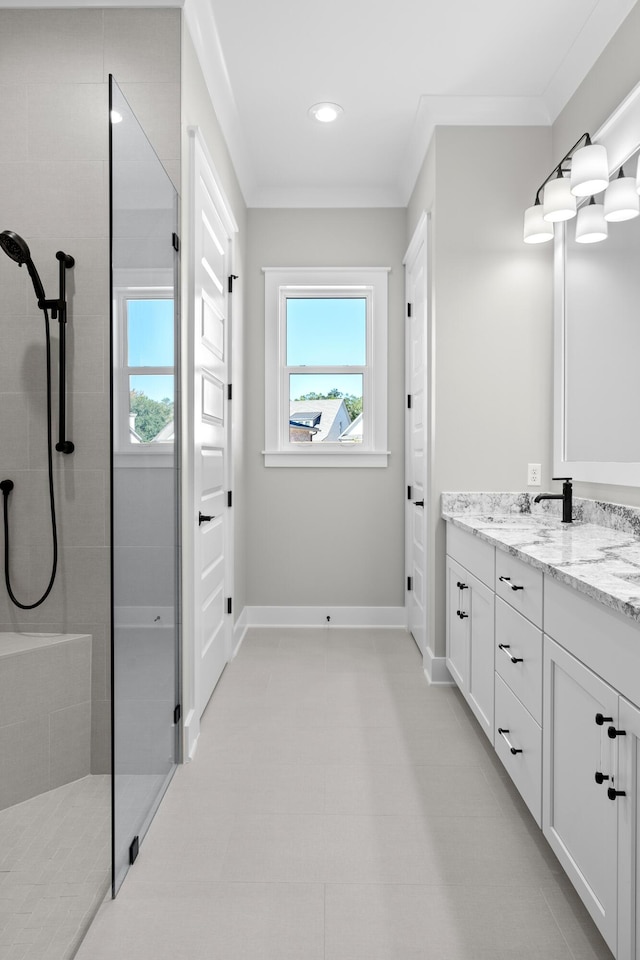 bathroom with vanity, a tile shower, ornamental molding, and a wealth of natural light