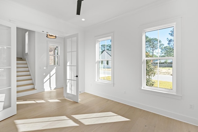 interior space with crown molding, french doors, and light hardwood / wood-style floors