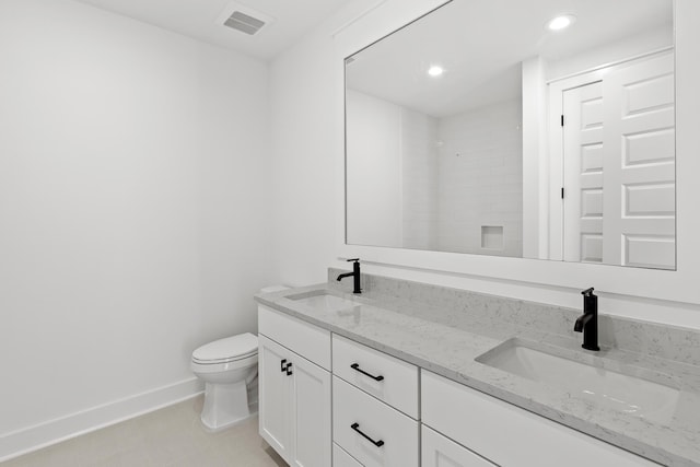 bathroom with tile patterned flooring, vanity, toilet, and walk in shower