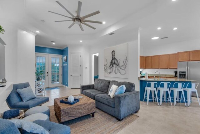 living room with french doors, light tile patterned floors, sink, and ceiling fan