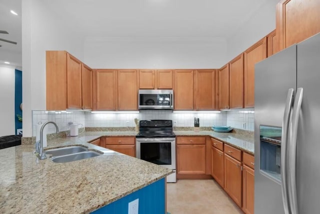 kitchen with light stone counters, stainless steel appliances, decorative backsplash, and sink