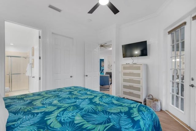 bedroom featuring ensuite bathroom, french doors, light hardwood / wood-style floors, ornamental molding, and ceiling fan