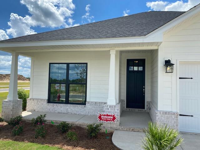 doorway to property with a garage and a porch