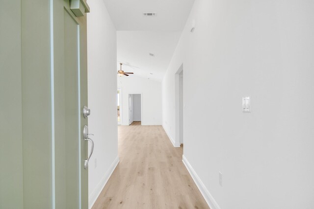 corridor with vaulted ceiling and light hardwood / wood-style floors