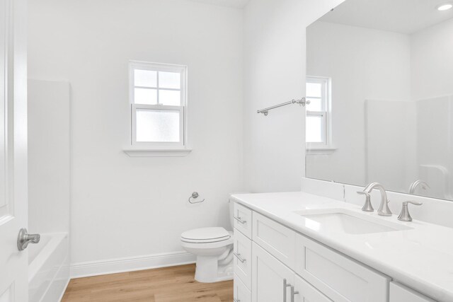 bathroom featuring vanity, toilet, and hardwood / wood-style flooring