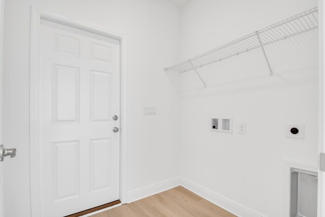 clothes washing area featuring hookup for a washing machine, light hardwood / wood-style flooring, and hookup for an electric dryer