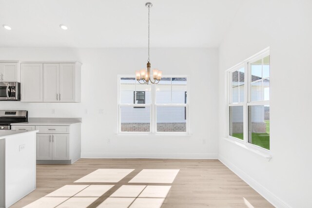 kitchen featuring plenty of natural light, stainless steel appliances, light wood-type flooring, and white cabinetry