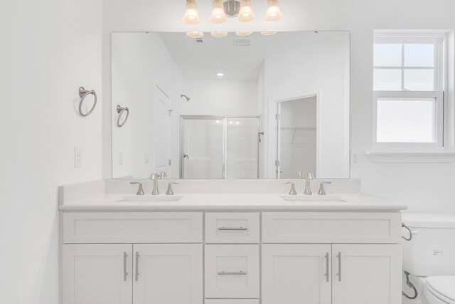 bathroom with a shower with door, vanity, and toilet