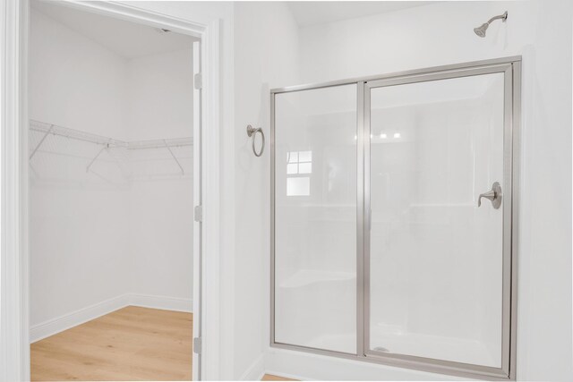 bathroom featuring an enclosed shower and wood-type flooring