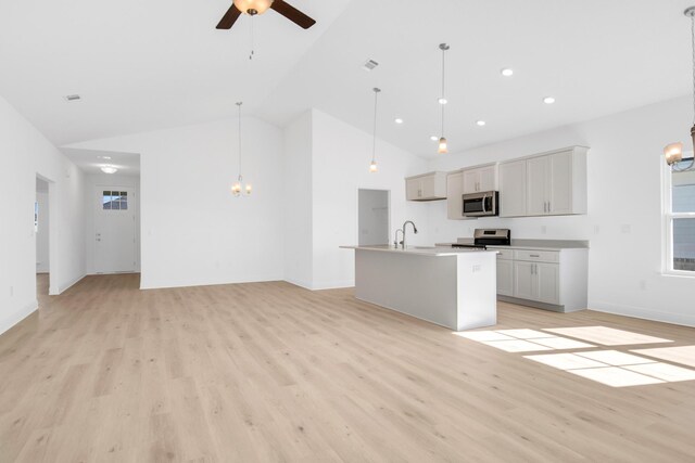 kitchen featuring a center island with sink, pendant lighting, appliances with stainless steel finishes, light hardwood / wood-style floors, and ceiling fan