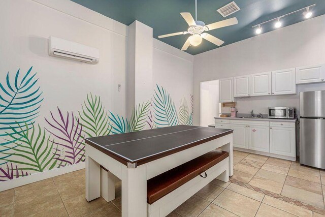 kitchen featuring ceiling fan, white cabinetry, stainless steel appliances, and a wall mounted air conditioner