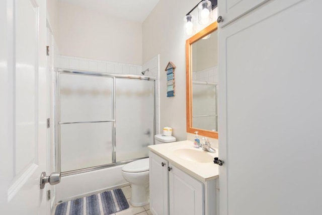 full bathroom with shower / bath combination with glass door, tile patterned flooring, toilet, and vanity