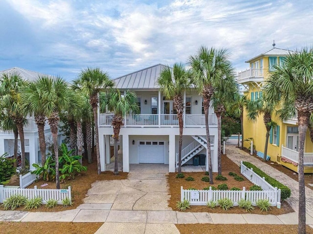 coastal inspired home with a garage and a porch