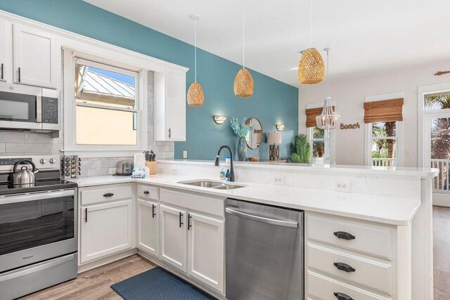 kitchen with white cabinets, appliances with stainless steel finishes, and backsplash