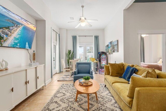 tiled living room featuring ceiling fan and french doors