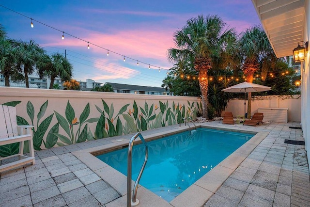 pool at dusk featuring a patio area