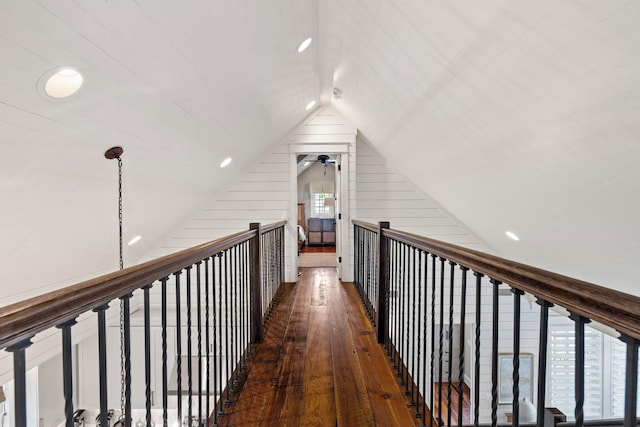 hallway with dark wood-type flooring and vaulted ceiling