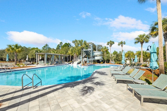 view of swimming pool with a pergola, a patio area, and a water slide