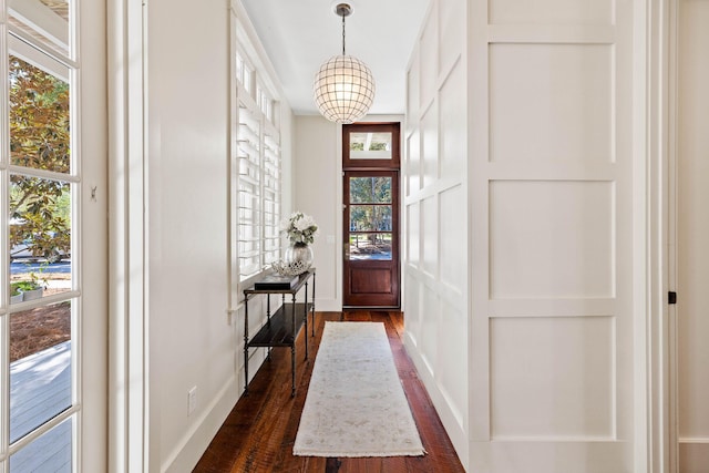 doorway to outside featuring a chandelier and dark hardwood / wood-style flooring