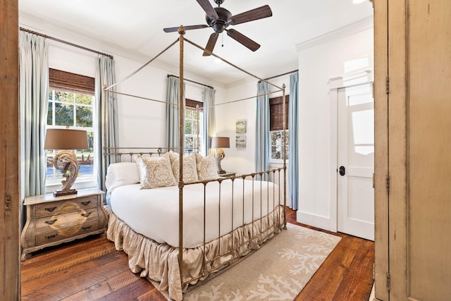 bedroom with crown molding, dark wood-type flooring, and ceiling fan