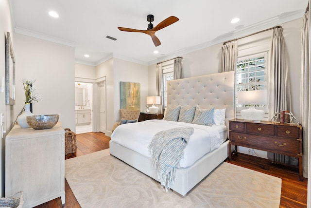 bedroom featuring multiple windows, wood-type flooring, ornamental molding, and ensuite bath