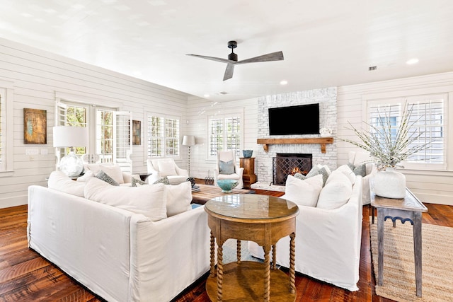 living room featuring dark hardwood / wood-style flooring, plenty of natural light, ceiling fan, and a fireplace