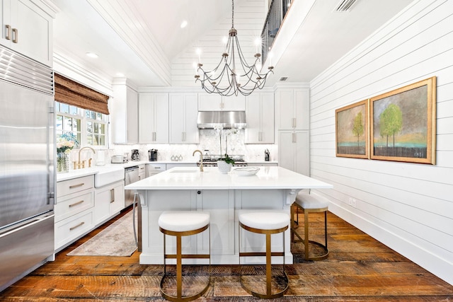 kitchen featuring white cabinetry, stainless steel appliances, and a kitchen island with sink