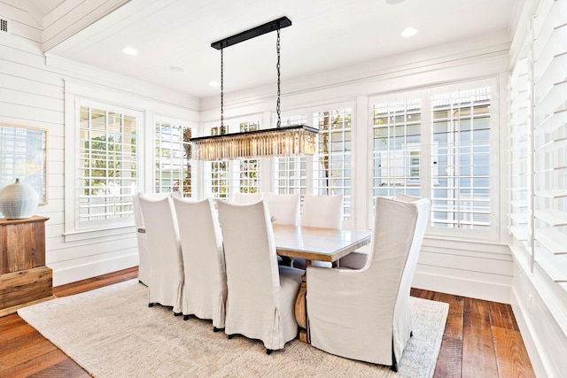 dining space featuring wood-type flooring, a wealth of natural light, and wood walls