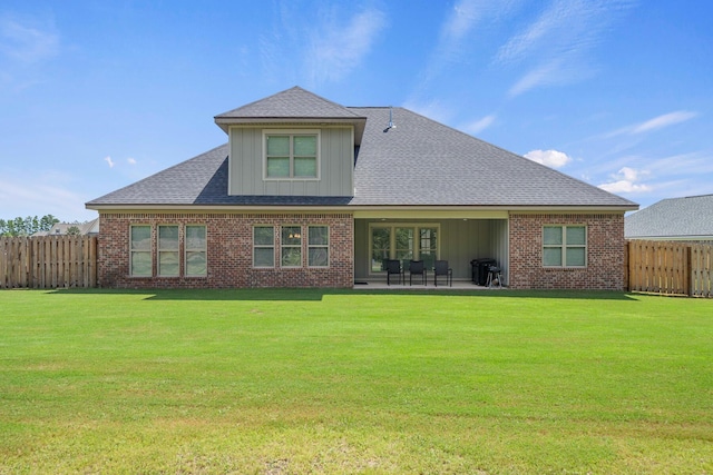 back of property featuring a patio, a lawn, brick siding, and a fenced backyard