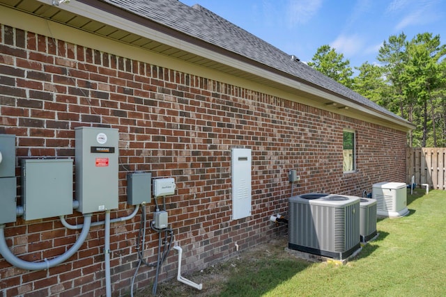 view of property exterior featuring cooling unit, brick siding, and a shingled roof