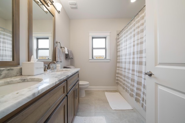 full bathroom featuring a sink, toilet, a healthy amount of sunlight, and double vanity