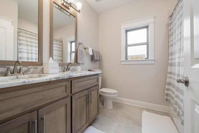 bathroom featuring double vanity, a healthy amount of sunlight, and a sink