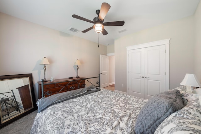 carpeted bedroom with visible vents, baseboards, a closet, and ceiling fan