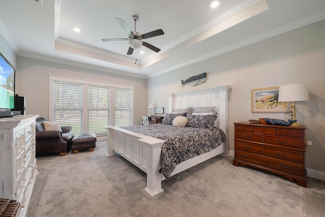 bedroom with a tray ceiling, light colored carpet, ornamental molding, and a ceiling fan