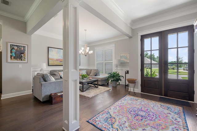 entryway with an inviting chandelier, crown molding, visible vents, and wood-type flooring