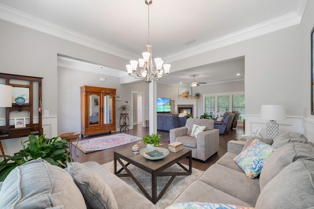 living area with light wood finished floors, visible vents, a wainscoted wall, ornamental molding, and a fireplace